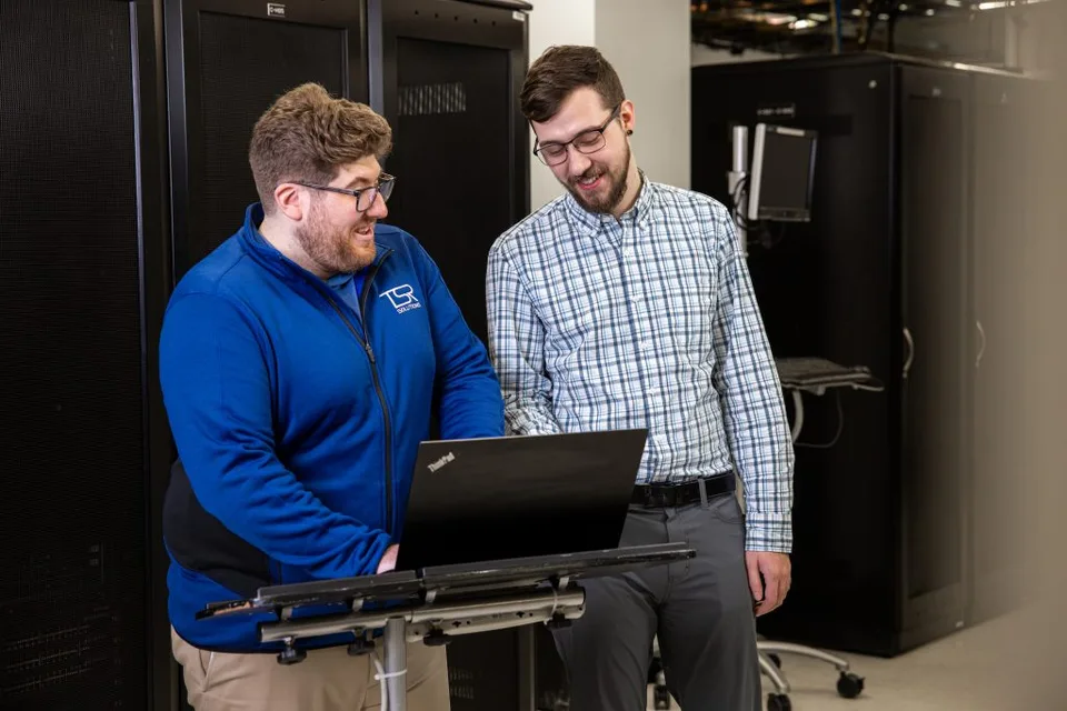 Two TSR colleagues working together at a laptop.
